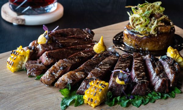 A well cooked steak presented on a wooden platter 