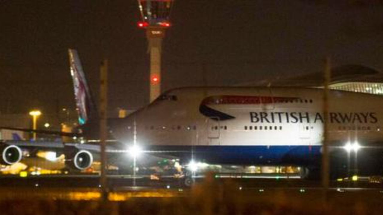 An aircraft taxis next to the control tower at Heathrow airport in London