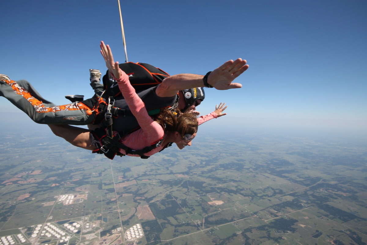 A tandem skydiver and instructor jumping from a plane, freefall at 11,000 feet, thrilling skydiving experience in Johannesburg, adrenaline rush, parachute glide over Pretoria, professional tandem masters, safe tandem jump, skydiving adventure, capturing jump on video, Wonderboom Airport skydiving, group skydiving packages, outdoor adventure activity, scenic aerial views, beginner-friendly skydiving, exciting Johannesburg activity, Joburg ETC