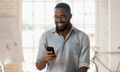 mobile banking app icons, cellphone USSD code screen, person using internet banking on laptop, Joburg skyline financial scene, Joburg ETC