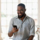 mobile banking app icons, cellphone USSD code screen, person using internet banking on laptop, Joburg skyline financial scene, Joburg ETC