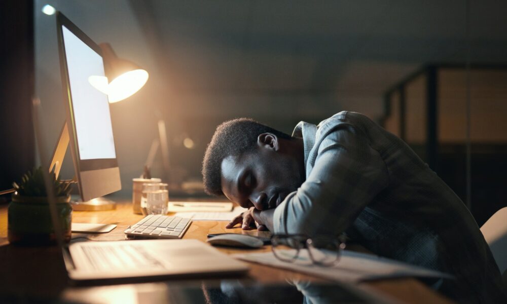 Employee checking work message after hours in Johannesburg, office lights glowing at night, South African worker setting healthy work boundaries, smartphone showing after-hours email notification, calm evening scene symbolising work-life balance, Joburg ETC