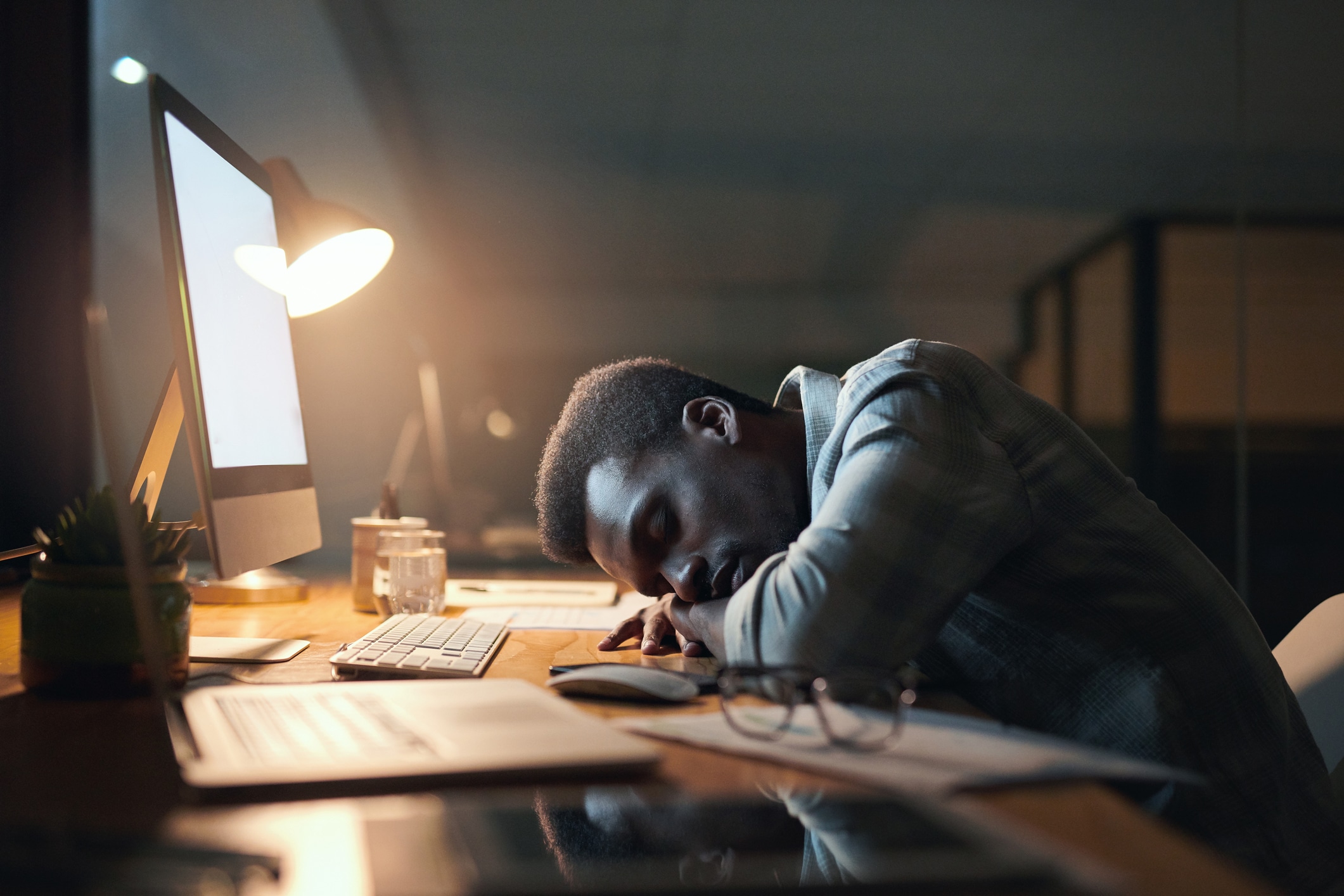 Employee checking work message after hours in Johannesburg, office lights glowing at night, South African worker setting healthy work boundaries, smartphone showing after-hours email notification, calm evening scene symbolising work-life balance, Joburg ETC