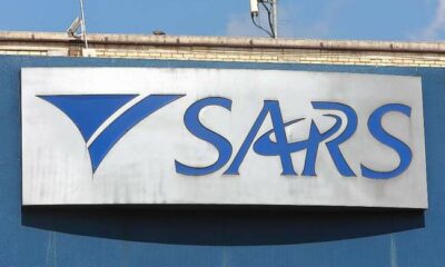 SARS office building, South African Revenue Service logo, corruption court case, police tender scandal, public procurement fraud South Africa, Johannesburg skyline at dusk, South African Police Service headquarters, tax fraud headlines, courtroom justice gavel, Grey Apple Trading Enterprise logo Joburg ETC