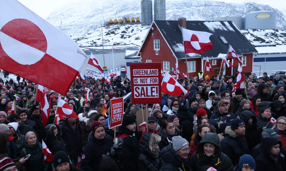 Greenland Nuuk skyline winter, Greenland Arctic town harbour scene, Greenland community preparing supplies, Greenland coastal settlement under dramatic sky, Joburg ETC