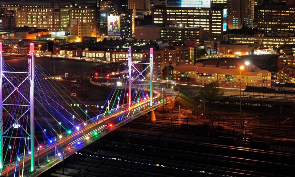 Night photography Johannesburg, Nelson Mandela Bridge at night, Sandton skyline 2026, Maboneng neon lights, Munro Drive viewpoint skyline, The Wilds Houghton night view, Carlton Centre Top of Africa lights, Montecasino night architecture, Villa Simonne fairy lights, Emmarentia Dam reflections, Joburg city lights panorama, Joburg ETC