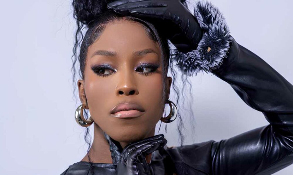 Ilano Big Brother Mzansi housemate, Ilano transgender contestant South Africa, Big Brother Mzansi season 2026 house interior, Ilano glam makeup Big Brother house, Ilano cooking in Big Brother Mzansi kitchen, South African reality TV representation LGBTQ, Big Brother Mzansi week seven eviction, Ilano portrait reality TV contestant, Mzansi Magic Big Brother housemates 2026, Joburg ETC