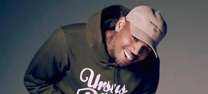 Chris Brown concert stage kiss, fan interaction Chris Brown live show, viral concert moment 2026, Chris Brown orange outfit stage lights, audience front row fan kiss, celebrity fan moment live performance, social media viral concert clip, Chris Brown crowd interaction moment, live music fan experience Johannesburg context, viral celebrity news moment Joburg ETC